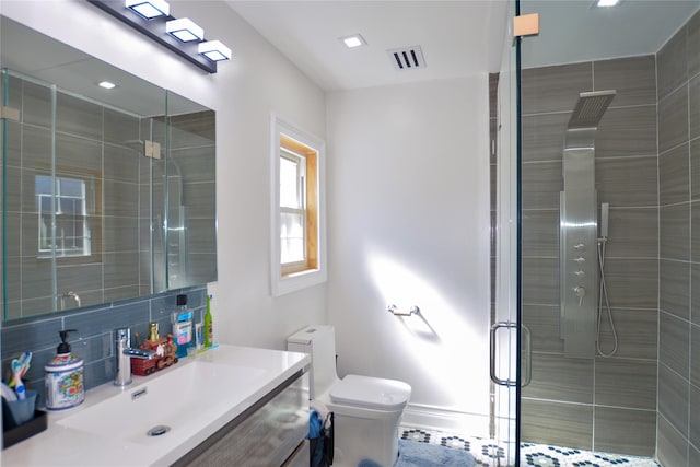 bathroom featuring vanity, a shower stall, toilet, and visible vents