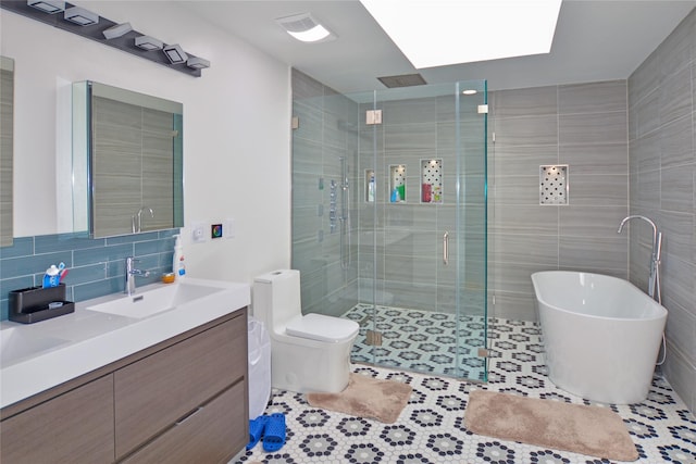 bathroom with tile patterned flooring, a stall shower, tasteful backsplash, and vanity