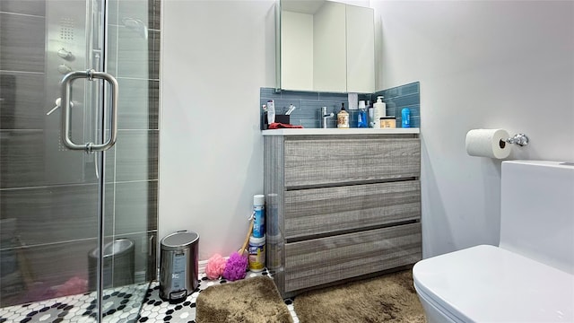 bathroom with vanity, a shower stall, and toilet