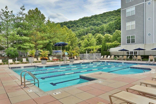 pool with a patio and fence