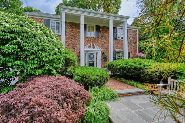 neoclassical / greek revival house featuring brick siding