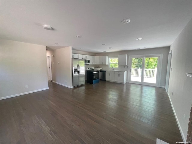 unfurnished living room featuring a sink, recessed lighting, baseboards, and dark wood-style flooring