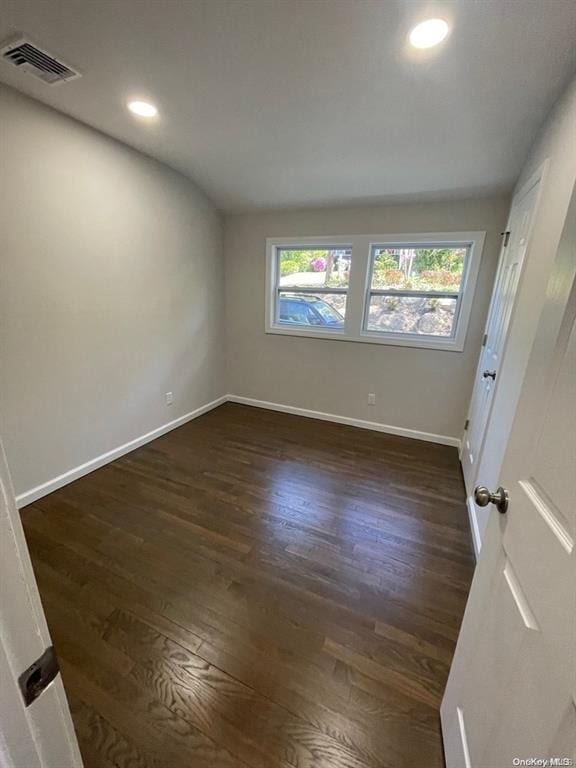 empty room featuring recessed lighting, visible vents, baseboards, and dark wood-style flooring