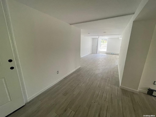 interior space featuring baseboards, wood tiled floor, and a baseboard radiator