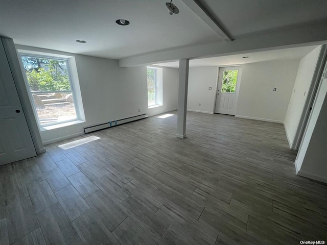 interior space featuring wood finish floors, a healthy amount of sunlight, and a baseboard radiator