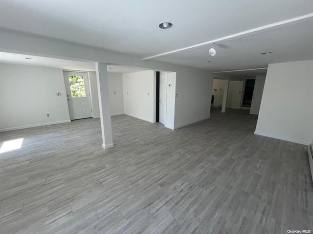 basement with baseboards and light wood-style floors