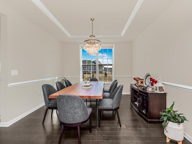 dining room with a tray ceiling, crown molding, dark wood-style flooring, and a chandelier