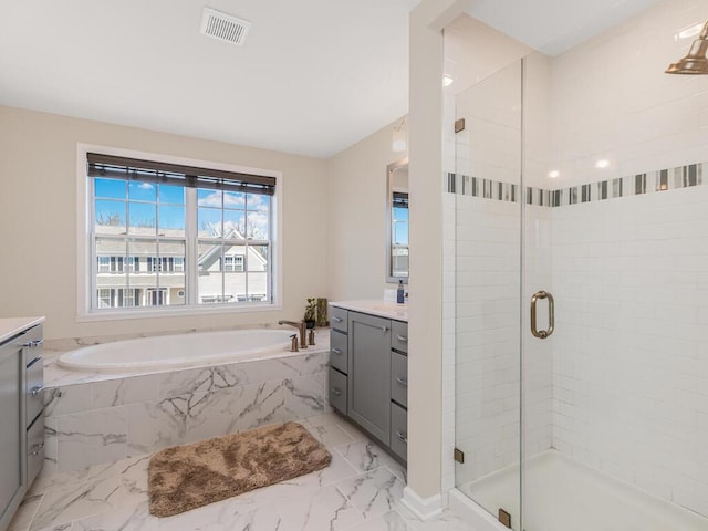 bathroom with visible vents, marble finish floor, a stall shower, a bath, and vanity