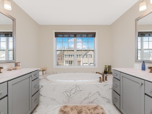 full bath featuring two vanities, plenty of natural light, and marble finish floor