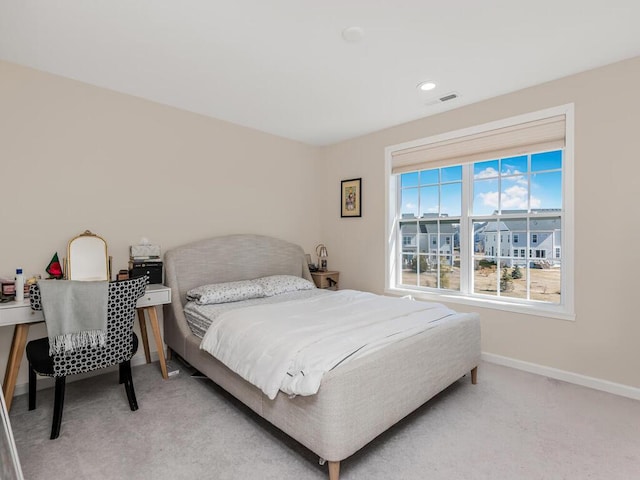 bedroom with light colored carpet, visible vents, and baseboards