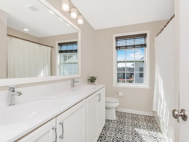 full bathroom featuring toilet, baseboards, visible vents, and a sink