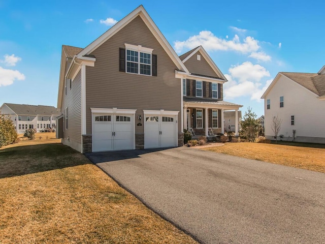 craftsman-style house featuring aphalt driveway, stone siding, an attached garage, and a front yard