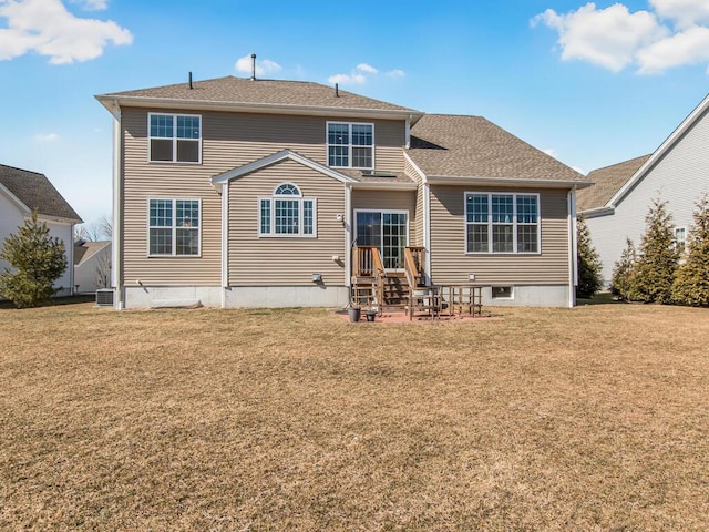 back of property featuring a lawn and a shingled roof