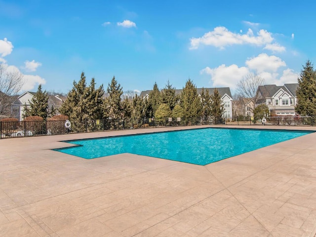 view of pool with a fenced in pool, a residential view, a patio area, and fence