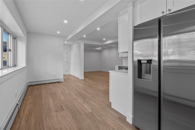 interior space with light wood-style flooring, a baseboard heating unit, white cabinets, and stainless steel fridge with ice dispenser