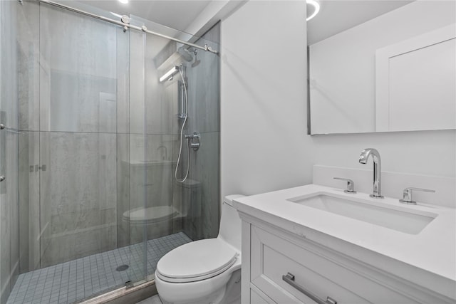 bathroom featuring toilet, a stall shower, and vanity