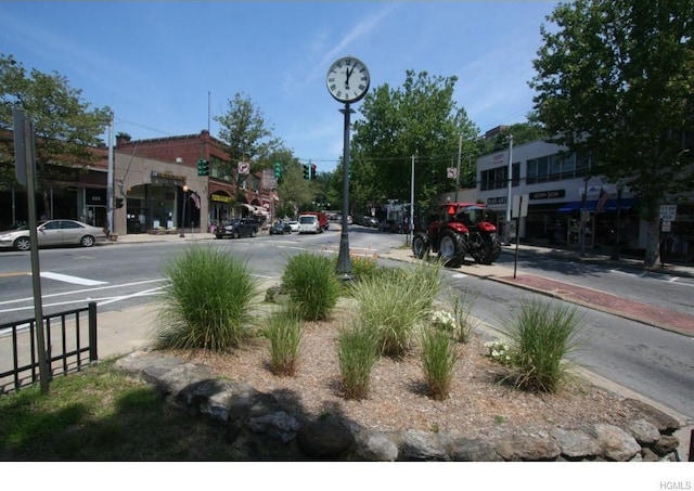 view of street with curbs, traffic signs, street lights, and sidewalks