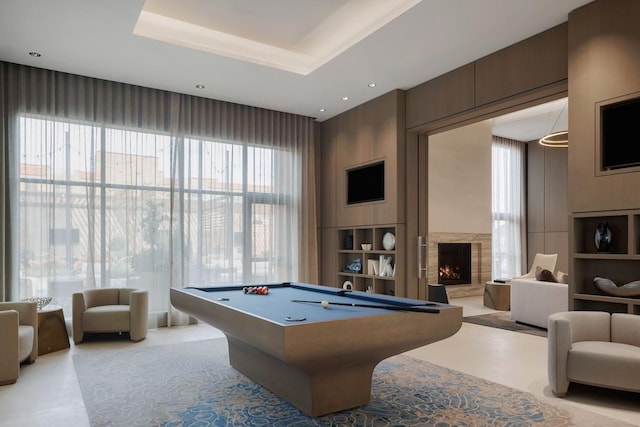 playroom with a high end fireplace, recessed lighting, pool table, and a tray ceiling