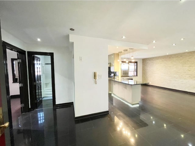 interior space with open floor plan, recessed lighting, a peninsula, and baseboards