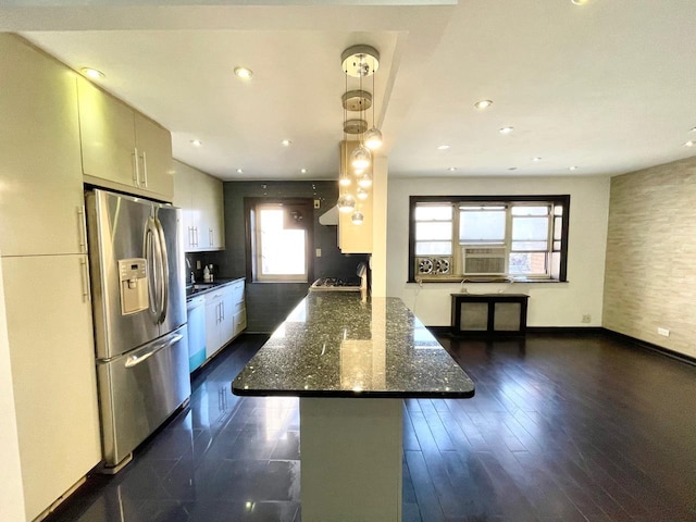 kitchen featuring dark wood-type flooring, stainless steel refrigerator with ice dispenser, dark stone countertops, a peninsula, and white dishwasher