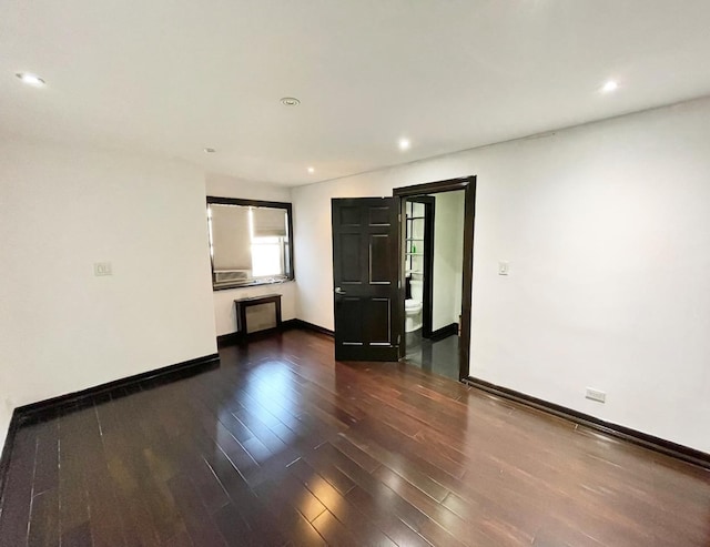 empty room featuring recessed lighting, baseboards, and wood finished floors