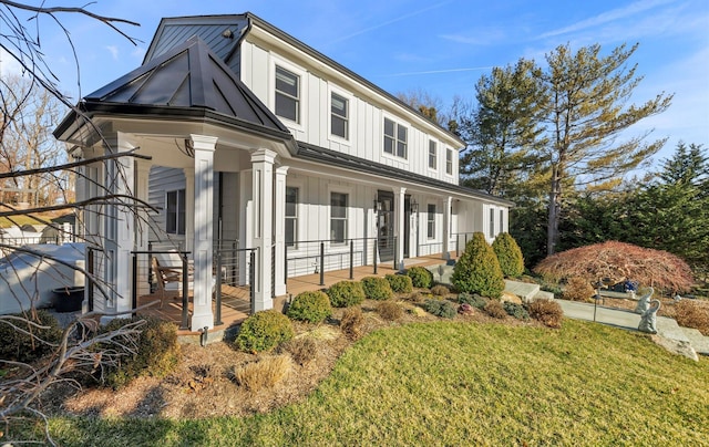 view of front facade featuring a porch, board and batten siding, and a front yard