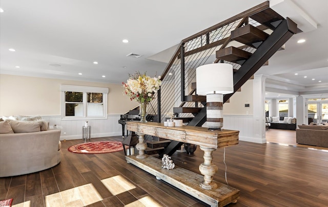 stairs featuring a wainscoted wall, crown molding, visible vents, and wood finished floors