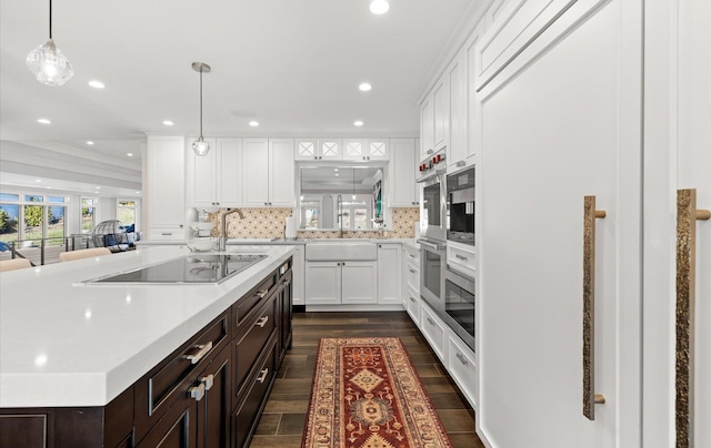 kitchen with backsplash, dark brown cabinets, black electric stovetop, light countertops, and white cabinetry