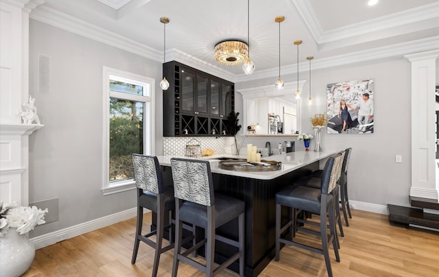 bar with wet bar, a healthy amount of sunlight, backsplash, and ornamental molding