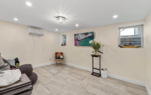 living area with a wall unit AC, recessed lighting, and baseboards