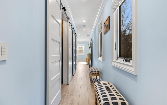 hall featuring recessed lighting, light wood-type flooring, and a barn door