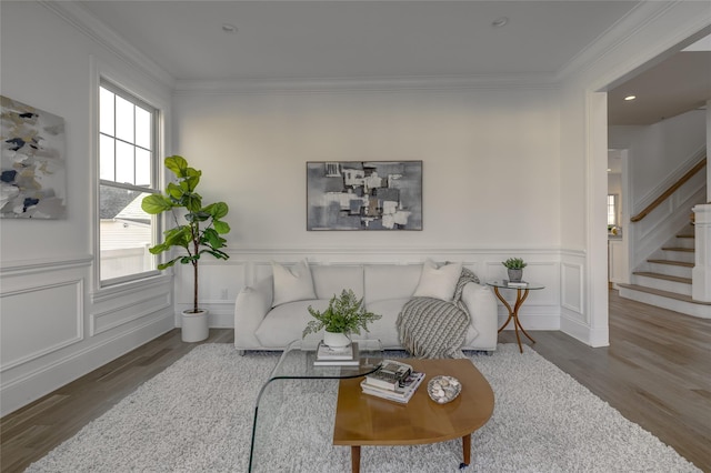 living area featuring stairway, wainscoting, wood finished floors, and crown molding