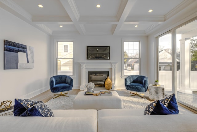 living room featuring beam ceiling, recessed lighting, wood finished floors, a glass covered fireplace, and coffered ceiling