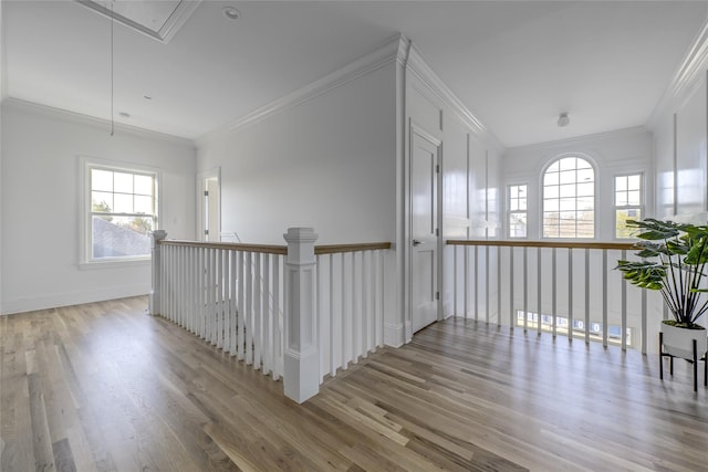 hall featuring wood finished floors, baseboards, attic access, crown molding, and an upstairs landing