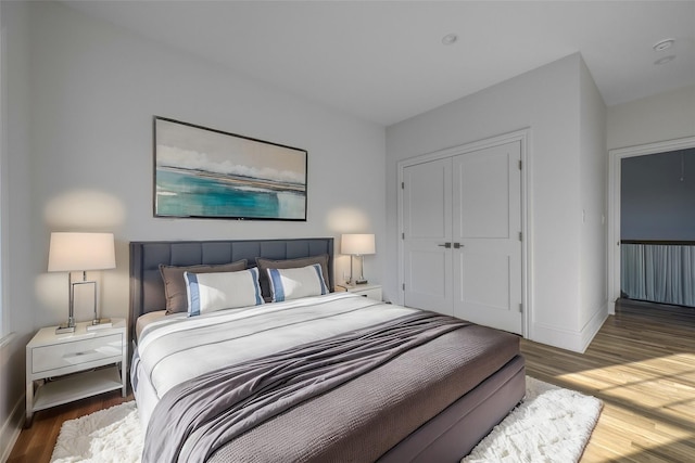 bedroom with a closet, baseboards, and wood finished floors