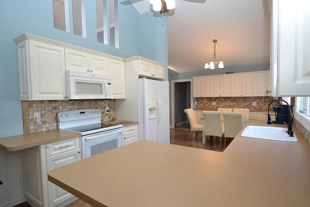 kitchen with a sink, tasteful backsplash, white cabinetry, white appliances, and a peninsula