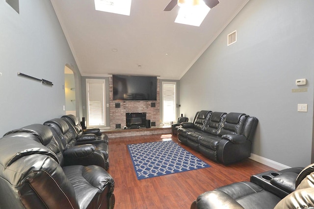 living area featuring visible vents, crown molding, ceiling fan, wood finished floors, and arched walkways