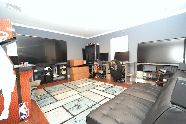 living room with visible vents, wood finished floors, and crown molding