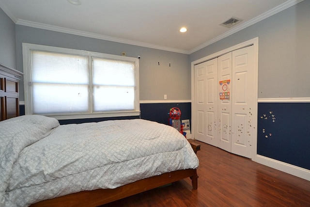 bedroom featuring wood finished floors, visible vents, and ornamental molding