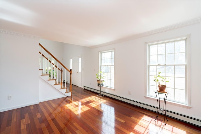 unfurnished room with wood finished floors, baseboards, a baseboard radiator, stairs, and crown molding