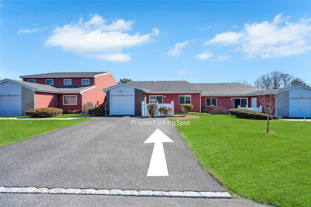 view of front of home with a garage, brick siding, a front lawn, and aphalt driveway