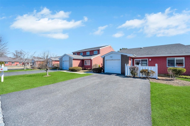 view of front of home featuring a front lawn, a garage, and aphalt driveway