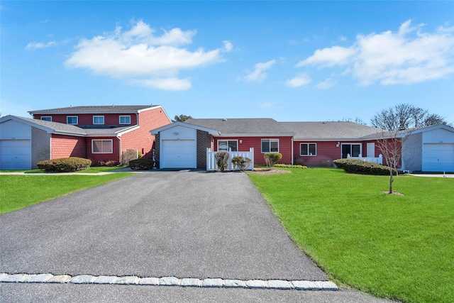 view of front of house with aphalt driveway, a garage, brick siding, and a front lawn