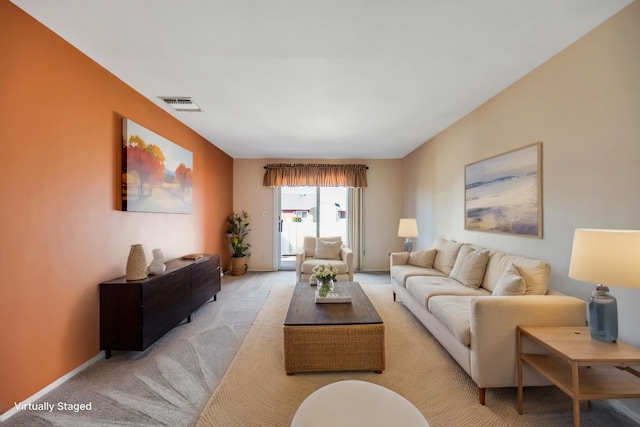 living room featuring visible vents, baseboards, and carpet flooring