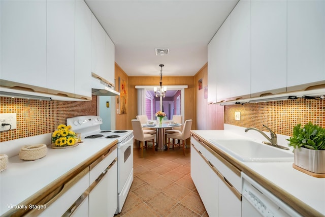 kitchen with under cabinet range hood, white cabinets, white appliances, and a sink