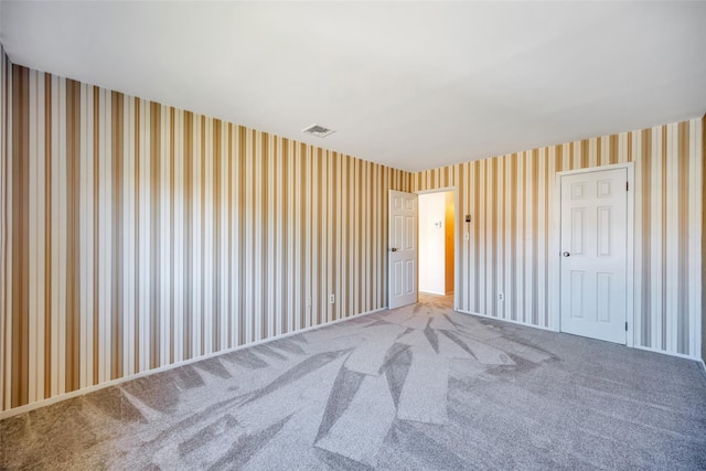 unfurnished bedroom featuring wallpapered walls, carpet flooring, and visible vents