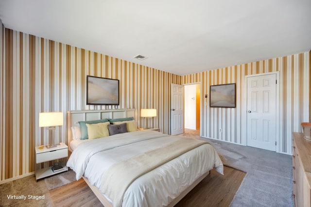 carpeted bedroom featuring visible vents and wallpapered walls