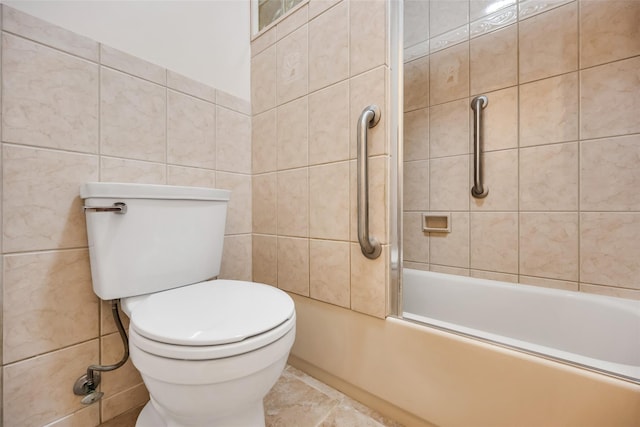 full bath featuring toilet, tile walls, and bathing tub / shower combination