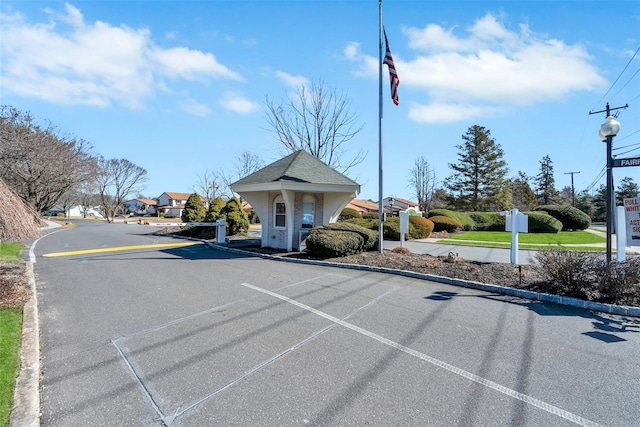 view of street featuring a gated entry and curbs