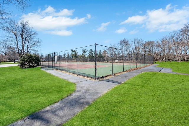 view of sport court with a yard and fence